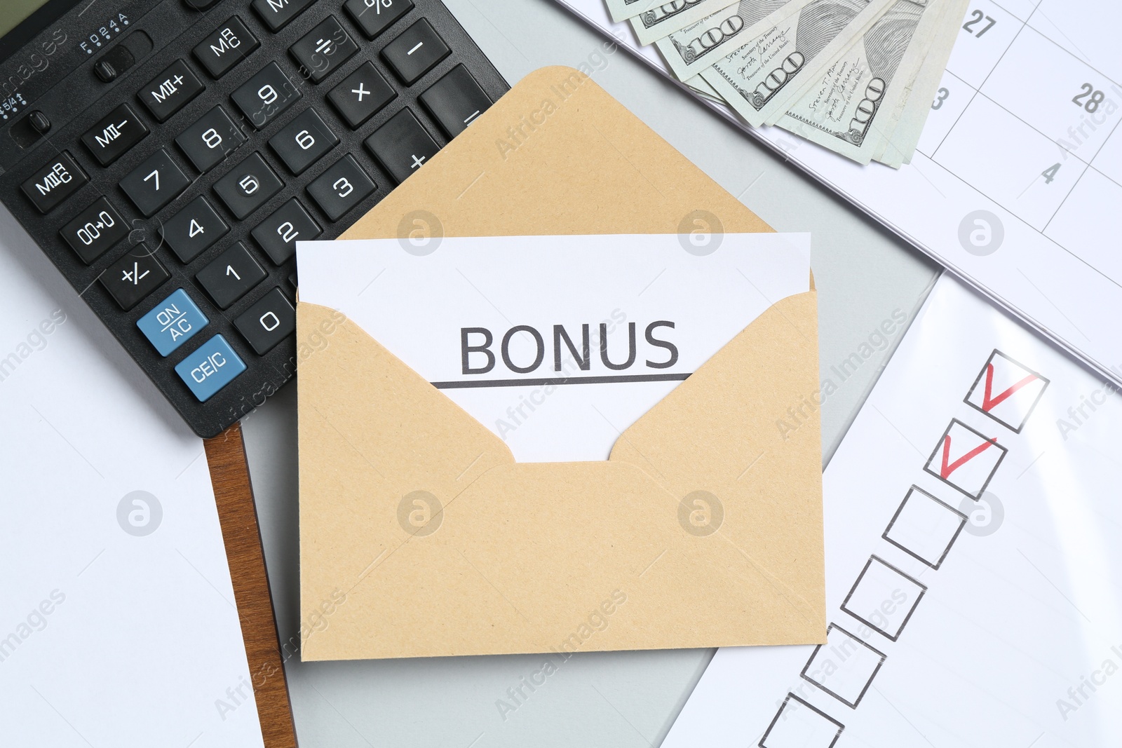 Envelope with word Bonus, money, calculator and paperwork on light grey background, flat lay Photo of Envelope with word Bonus, money, calculator and paperwork on light grey background, flat lay