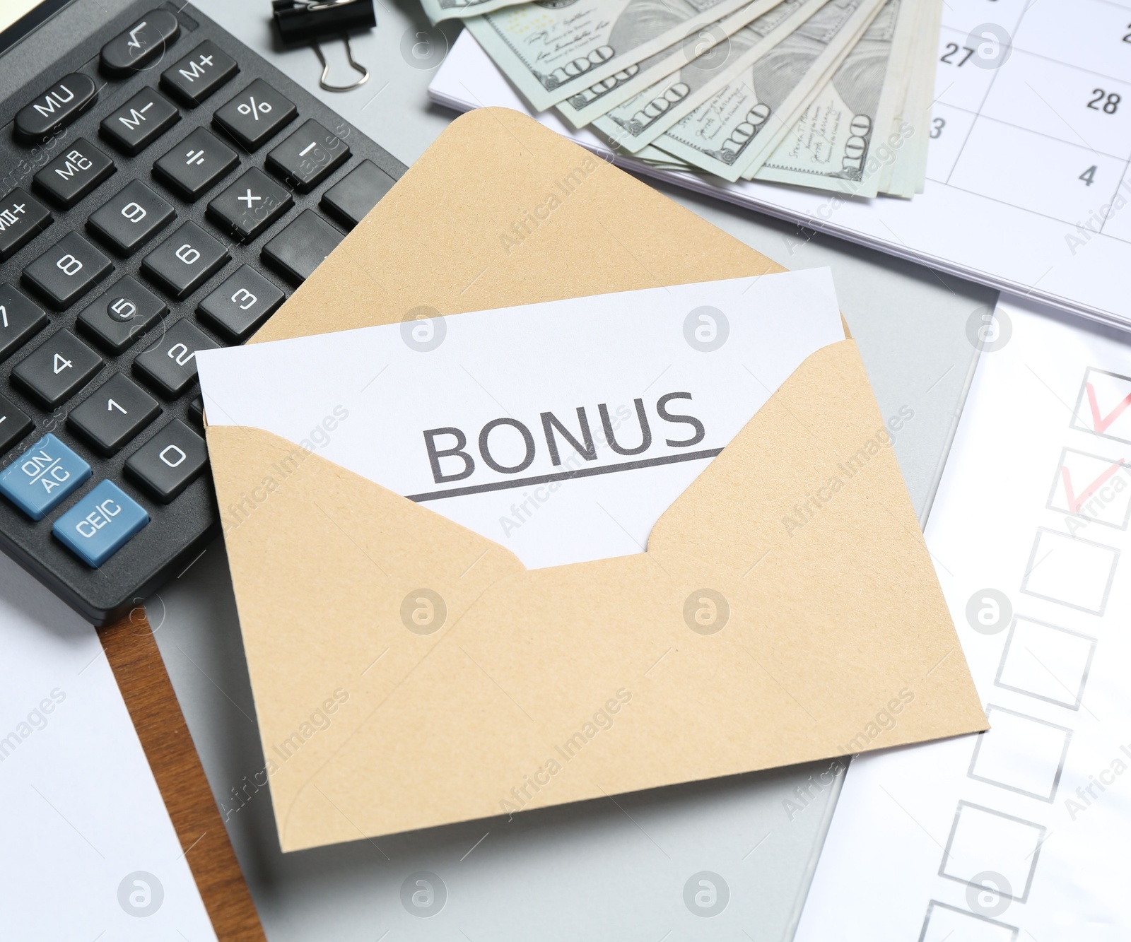 Envelope with word Bonus, money, calculator and paperwork on light grey background, closeup Photo of Envelope with word Bonus, money, calculator and paperwork on light grey background, closeup