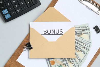 Photo of Envelope with word Bonus, money, calculator and paperwork on light grey background, flat lay