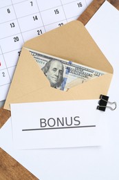 Photo of Envelope with money, word Bonus, clipboard and calendar on light grey background, flat lay