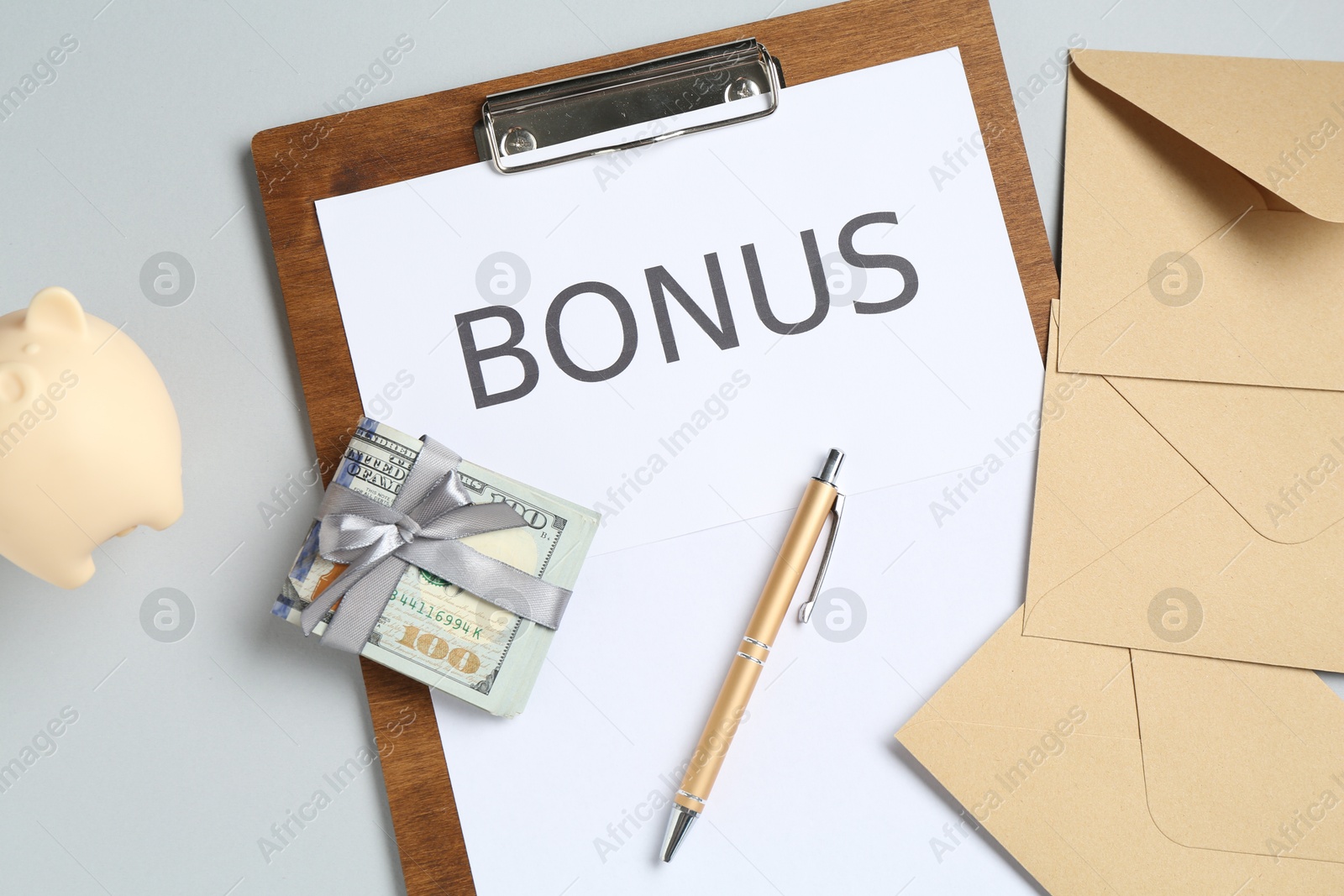 Clipboard with word Bonus, envelopes, money and piggybank on light grey background, flat lay Photo of Clipboard with word Bonus, envelopes, money and piggybank on light grey background, flat lay