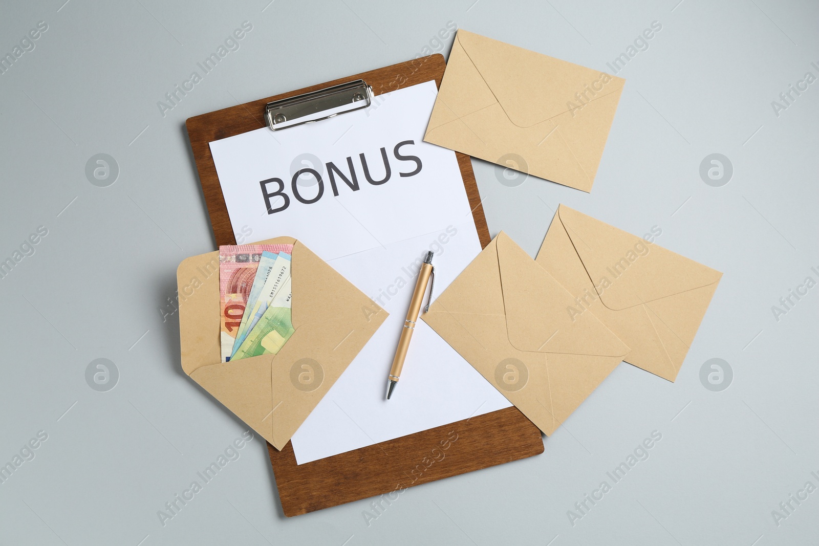 Clipboard with word Bonus and envelopes with money on light grey background, flat lay Photo of Clipboard with word Bonus and envelopes with money on light grey background, flat lay