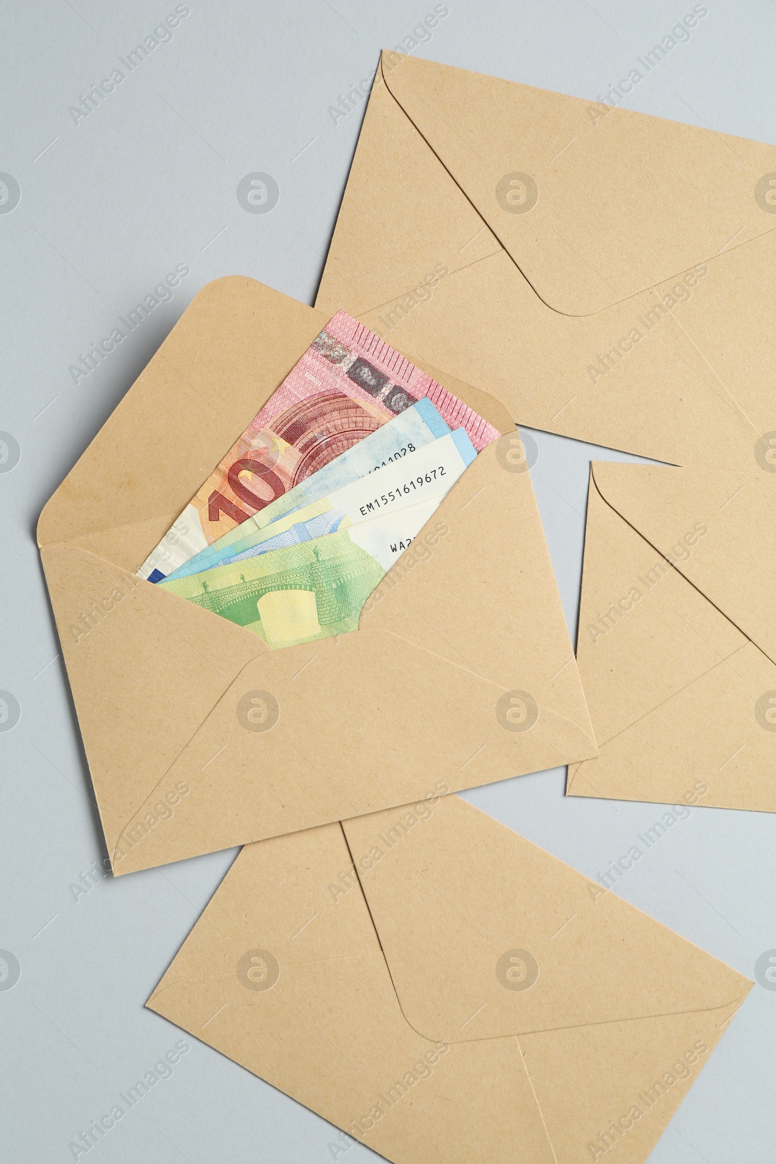 Money bonus. Envelopes with euro banknotes on light grey background, flat lay Photo of Money bonus. Envelopes with euro banknotes on light grey background, flat lay