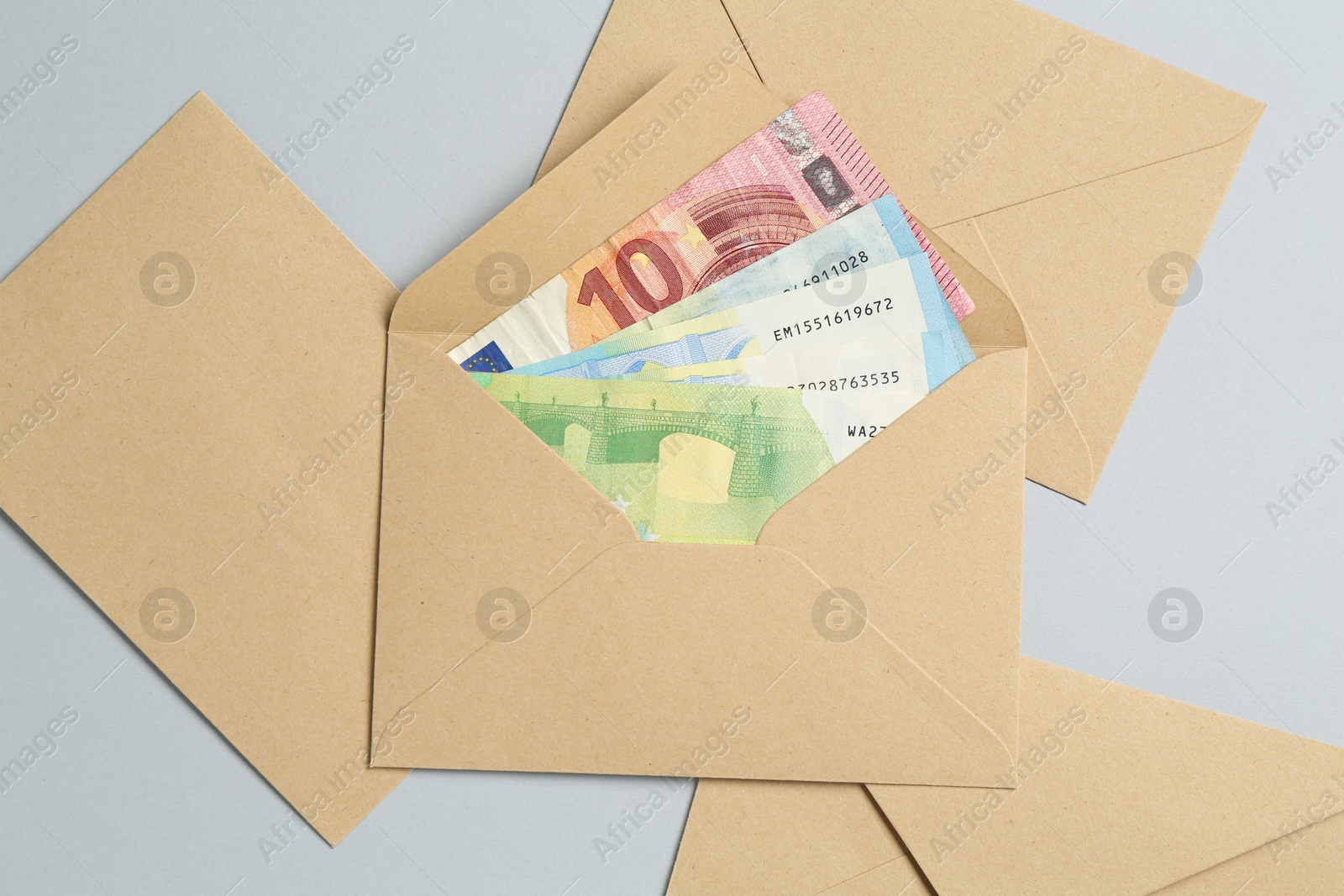 Money bonus. Envelopes with euro banknotes on light grey background, flat lay Photo of Money bonus. Envelopes with euro banknotes on light grey background, flat lay