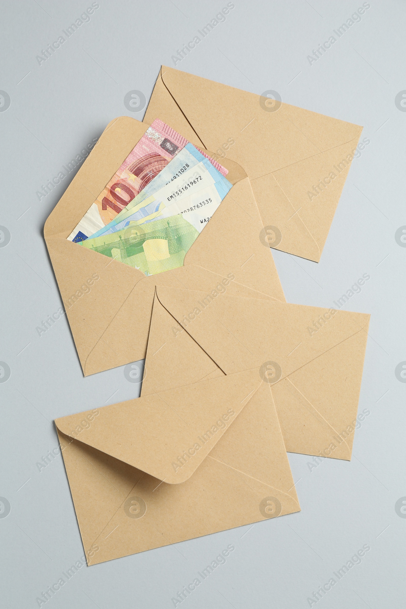 Money bonus. Envelopes with euro banknotes on light grey background, flat lay Photo of Money bonus. Envelopes with euro banknotes on light grey background, flat lay