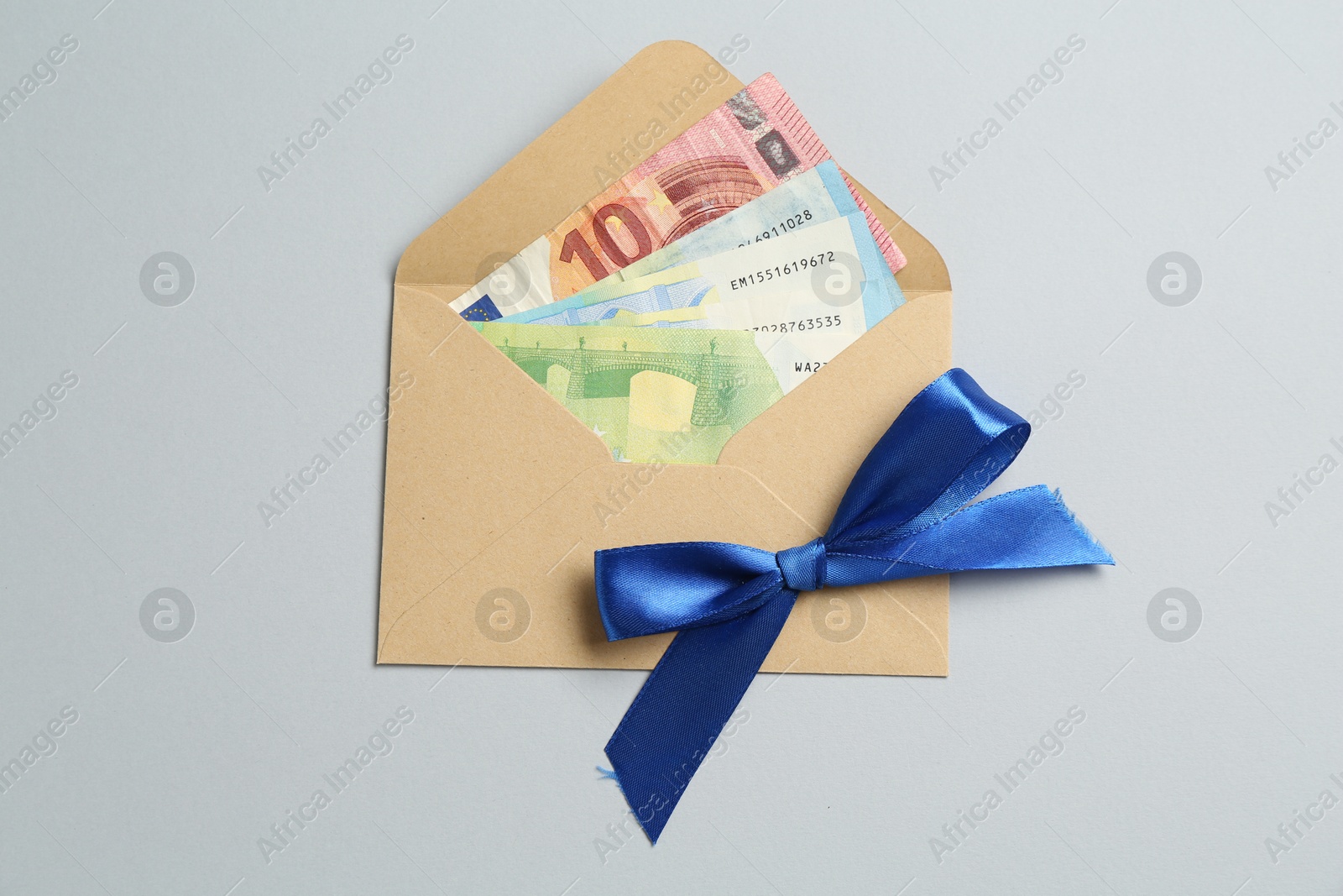Money bonus. Envelope with euro banknotes on light grey background, top view Photo of Money bonus. Envelope with euro banknotes on light grey background, top view