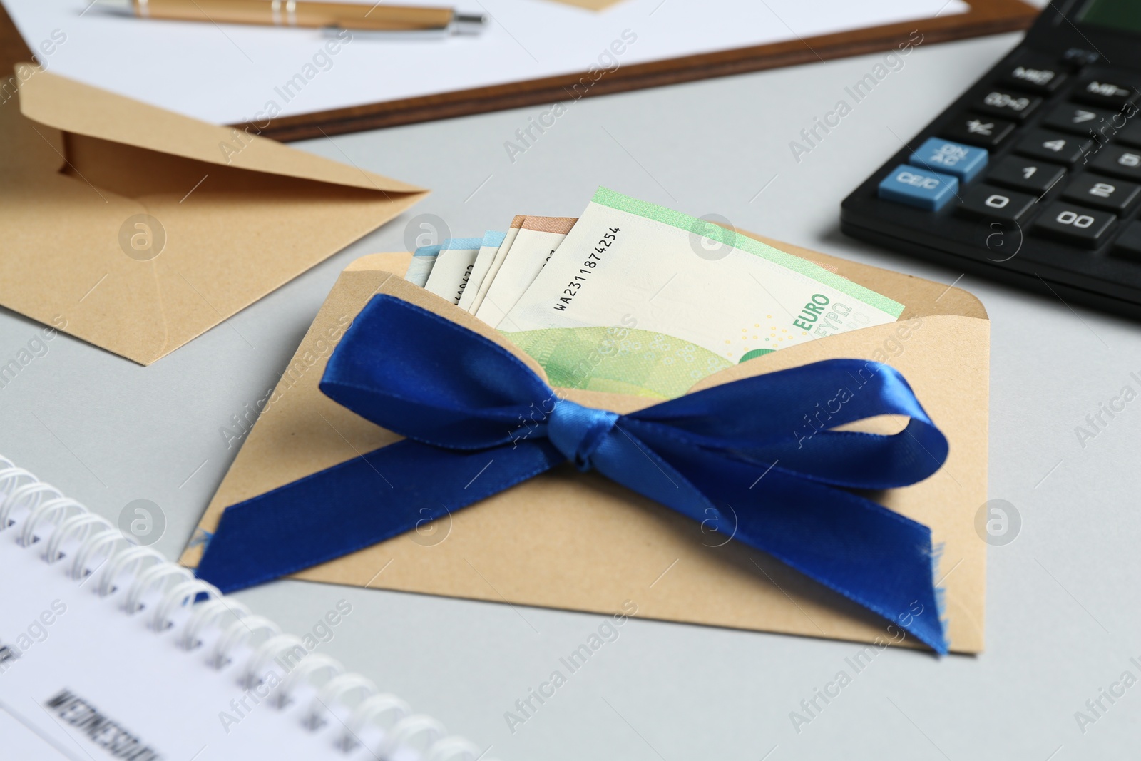 Money bonus. Envelope with euro banknotes on light grey background, closeup Photo of Money bonus. Envelope with euro banknotes on light grey background, closeup