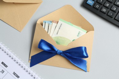 Photo of Money bonus. Envelope with euro banknotes on light grey background, flat lay