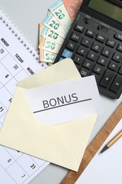 Photo of Card with word Bonus, money, calendar and calculator on light grey background, flat lay