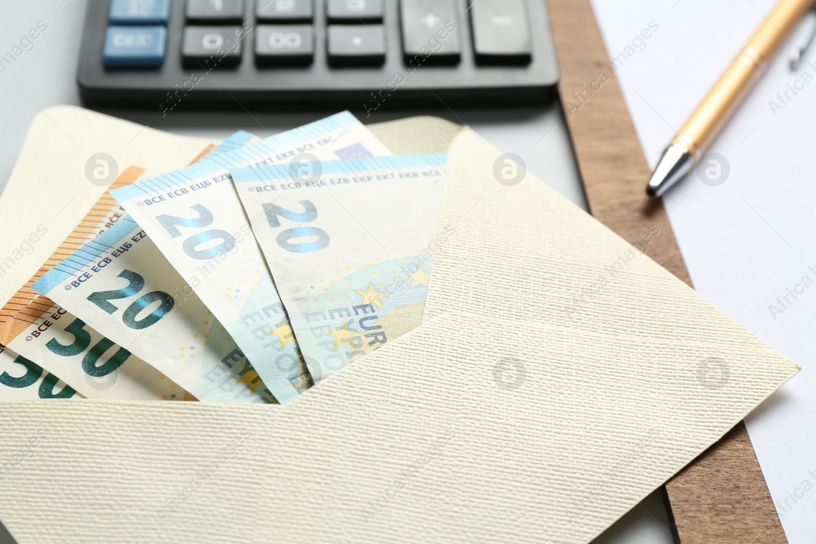 Money bonus. Envelope with euro banknotes on light grey background, closeup Photo of Money bonus. Envelope with euro banknotes on light grey background, closeup