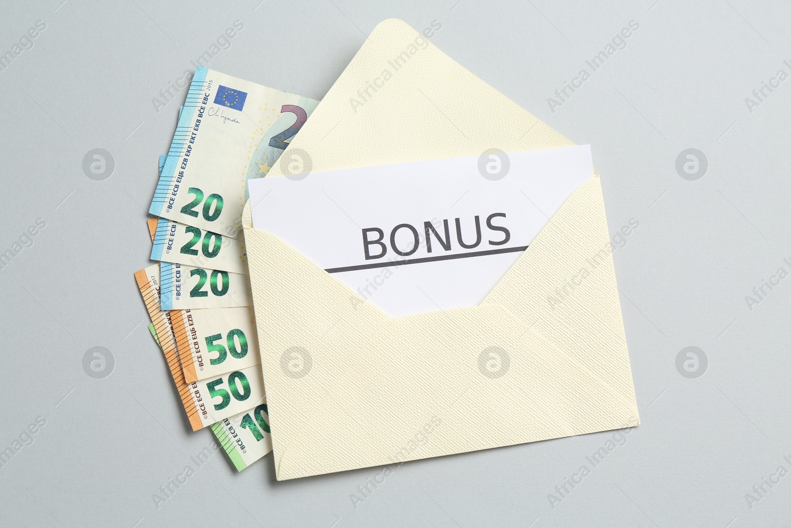 Envelope with money and word Bonus on light grey background, top view Photo of Envelope with money and word Bonus on light grey background, top view