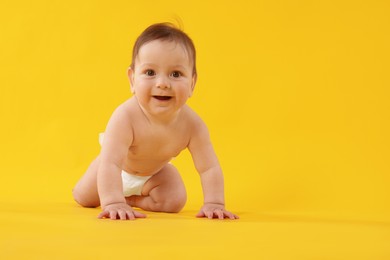 Photo of Cute little baby crawling on yellow background