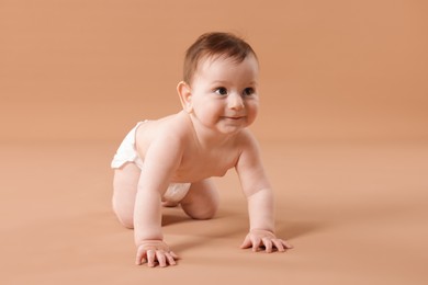 Photo of Cute little baby crawling on beige background