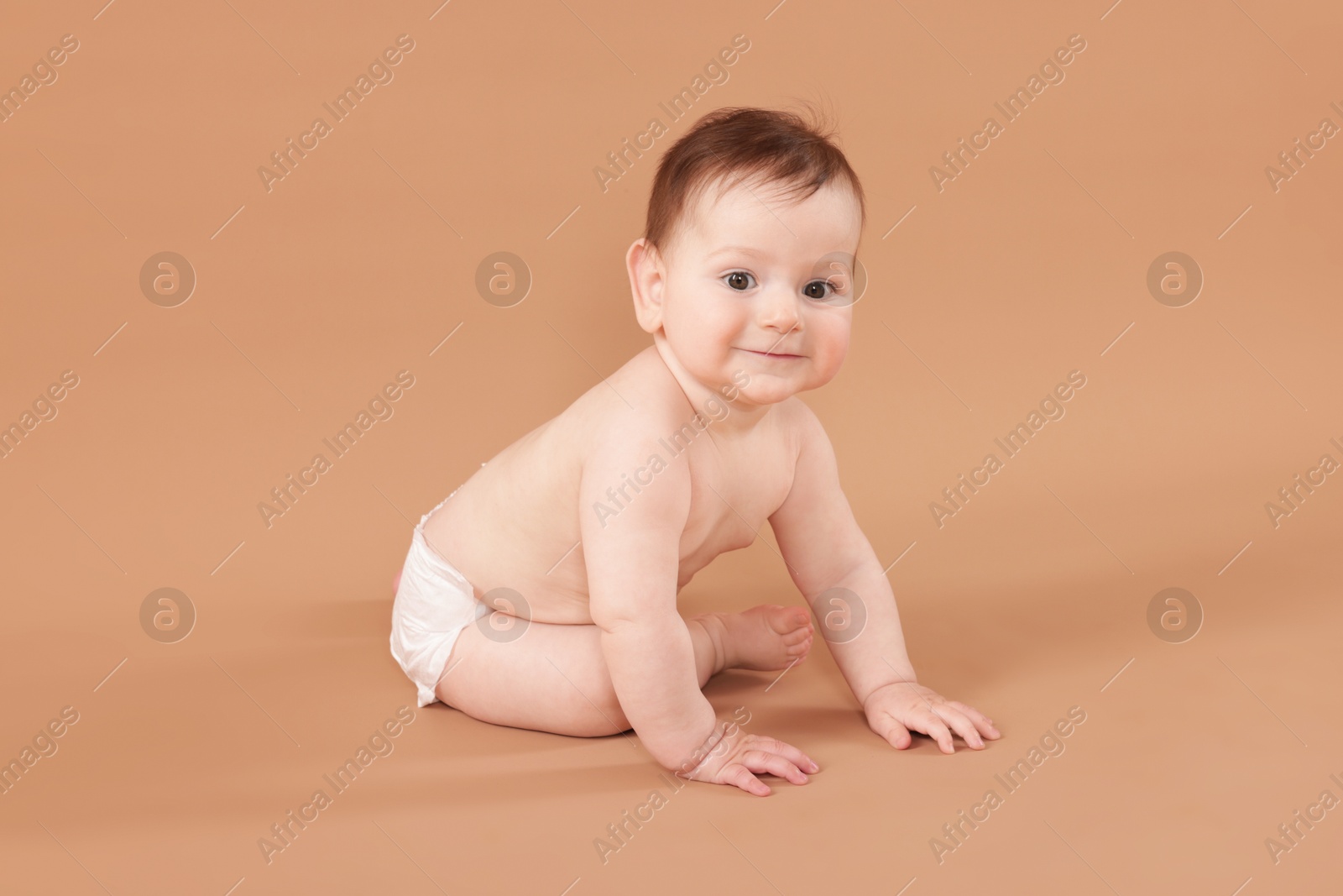 Cute little baby crawling on beige background Photo of Cute little baby crawling on beige background
