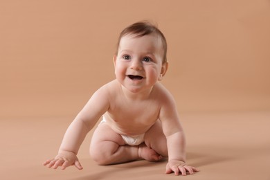 Photo of Cute little baby crawling on beige background