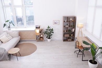 Photo of Stylish living room interior. Sofa, table, shelving unit and other furniture indoors, above view