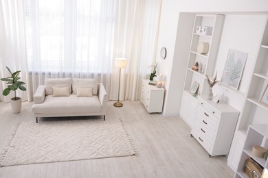 Photo of Stylish living room interior. Sofa, dresser, shelving unit and other furniture indoors, above view