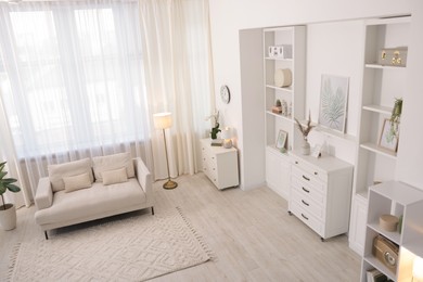 Photo of Stylish living room interior. Sofa, dresser, shelving unit and other furniture indoors, above view