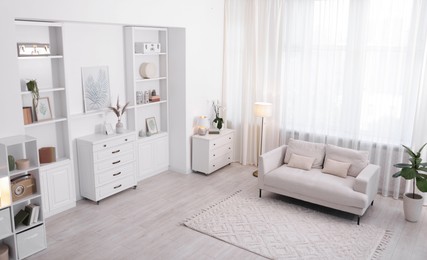 Photo of Stylish living room interior. Sofa, dresser, shelving unit and other furniture indoors, above view
