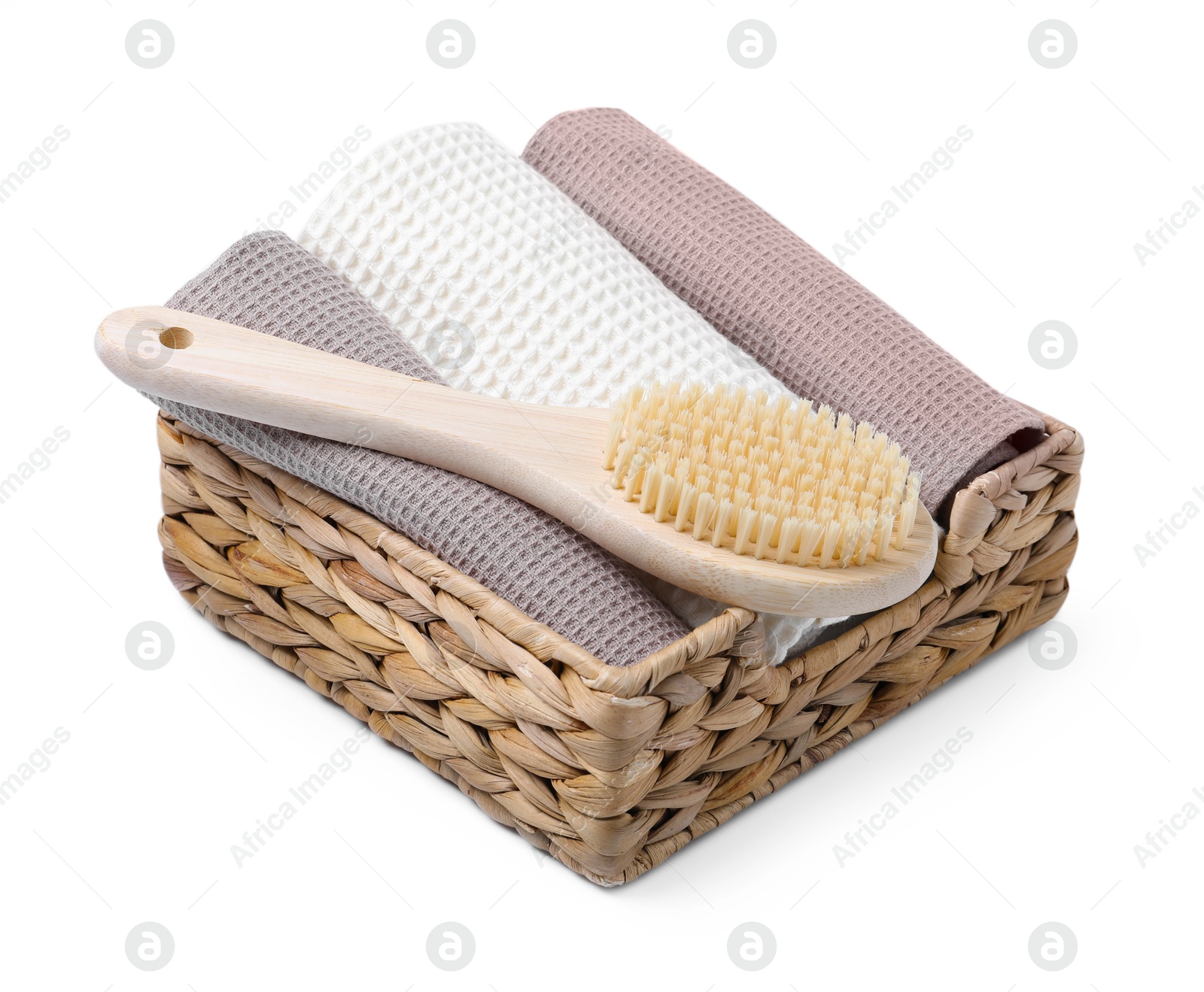 Clean waffle towels and brush in basket isolated on white Photo of Clean waffle towels and brush in basket isolated on white