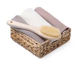 Photo of Clean waffle towels and brush in basket isolated on white