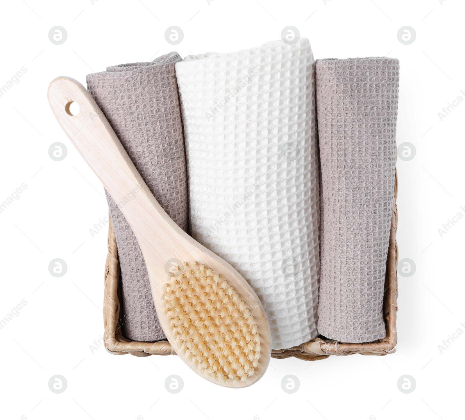 Clean waffle towels and brush in basket isolated on white, top view Photo of Clean waffle towels and brush in basket isolated on white, top view