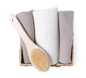 Photo of Clean waffle towels and brush in basket isolated on white, top view