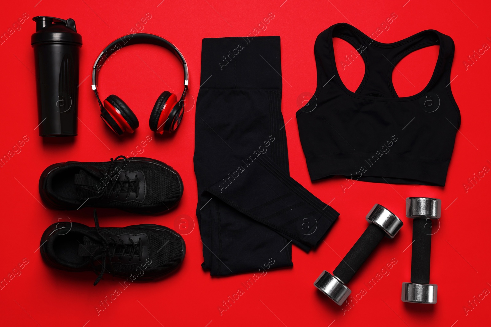 Sportswear, sneakers, dumbbells, headphones and water bottle on red background, flat lay Photo of Sportswear, sneakers, dumbbells, headphones and water bottle on red background, flat lay