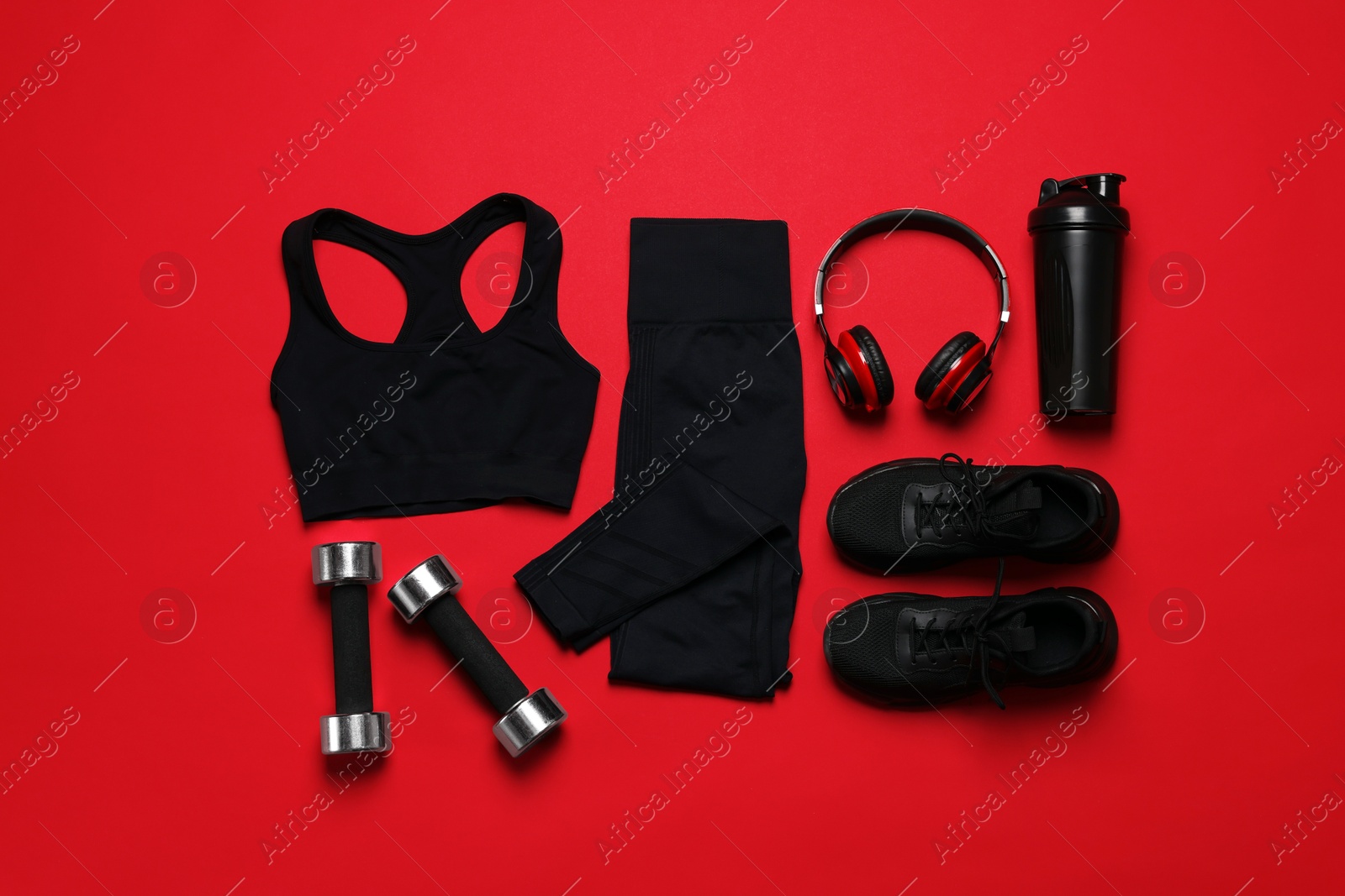 Sportswear, sneakers, dumbbells, headphones and water bottle on red background, flat lay Photo of Sportswear, sneakers, dumbbells, headphones and water bottle on red background, flat lay