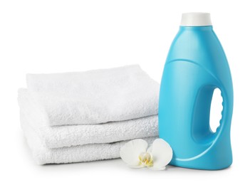 Photo of Bottle of fabric softener, stacked towels and flower isolated on white