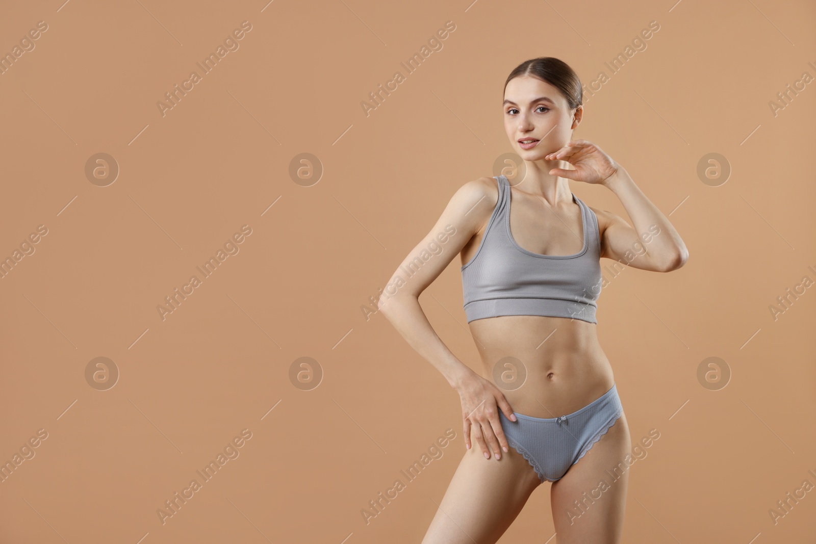 Woman wearing beautiful underwear on dark beige background, space for text Photo of Woman wearing beautiful underwear on dark beige background, space for text