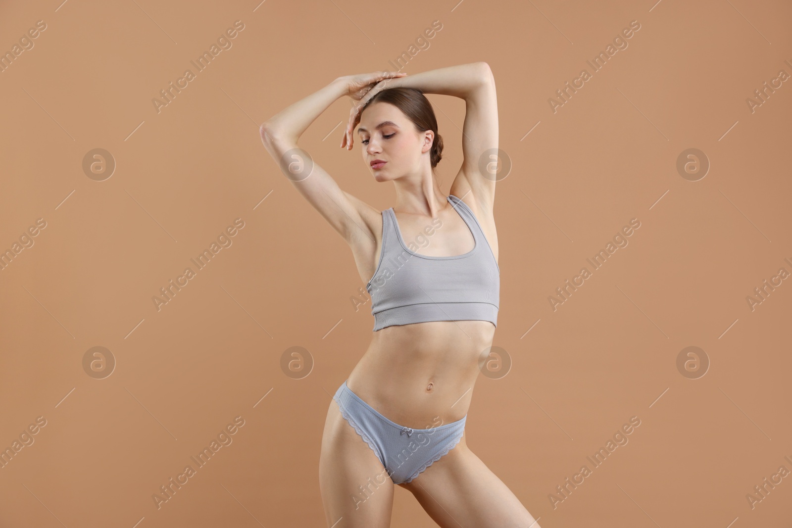 Woman wearing beautiful underwear on dark beige background Photo of Woman wearing beautiful underwear on dark beige background