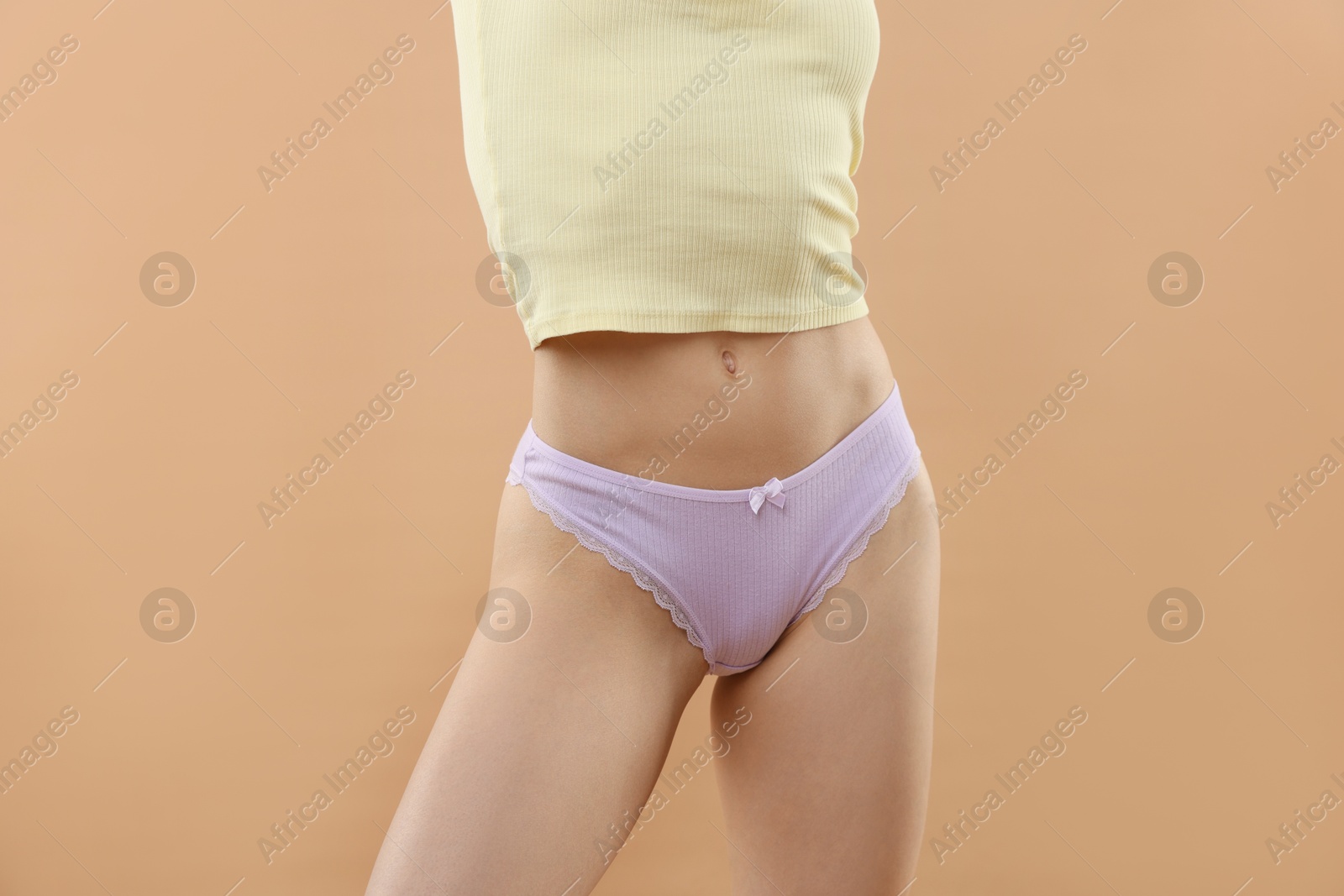 Woman wearing beautiful underwear on beige background, closeup Photo of Woman wearing beautiful underwear on beige background, closeup