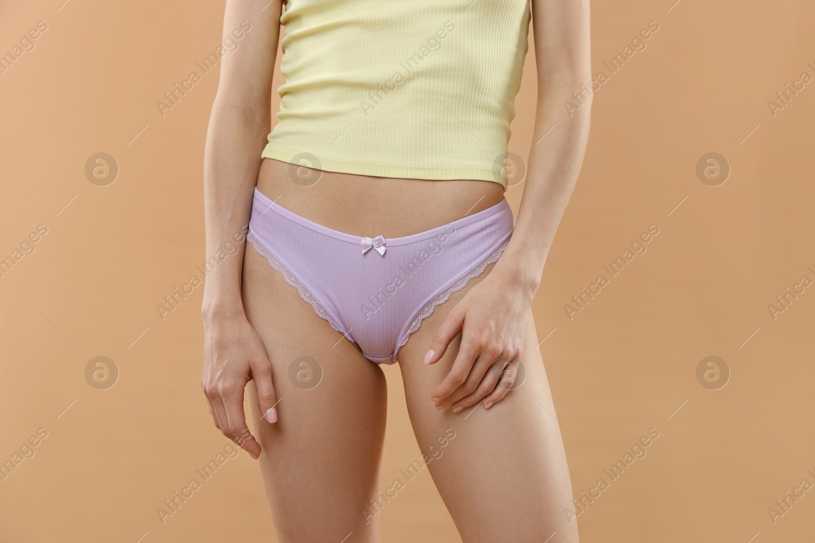 Woman wearing beautiful underwear on beige background, closeup Photo of Woman wearing beautiful underwear on beige background, closeup