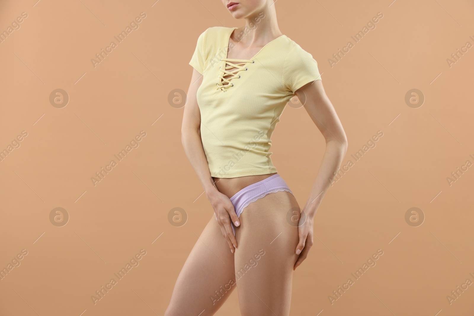 Woman wearing beautiful underwear on beige background, closeup Photo of Woman wearing beautiful underwear on beige background, closeup