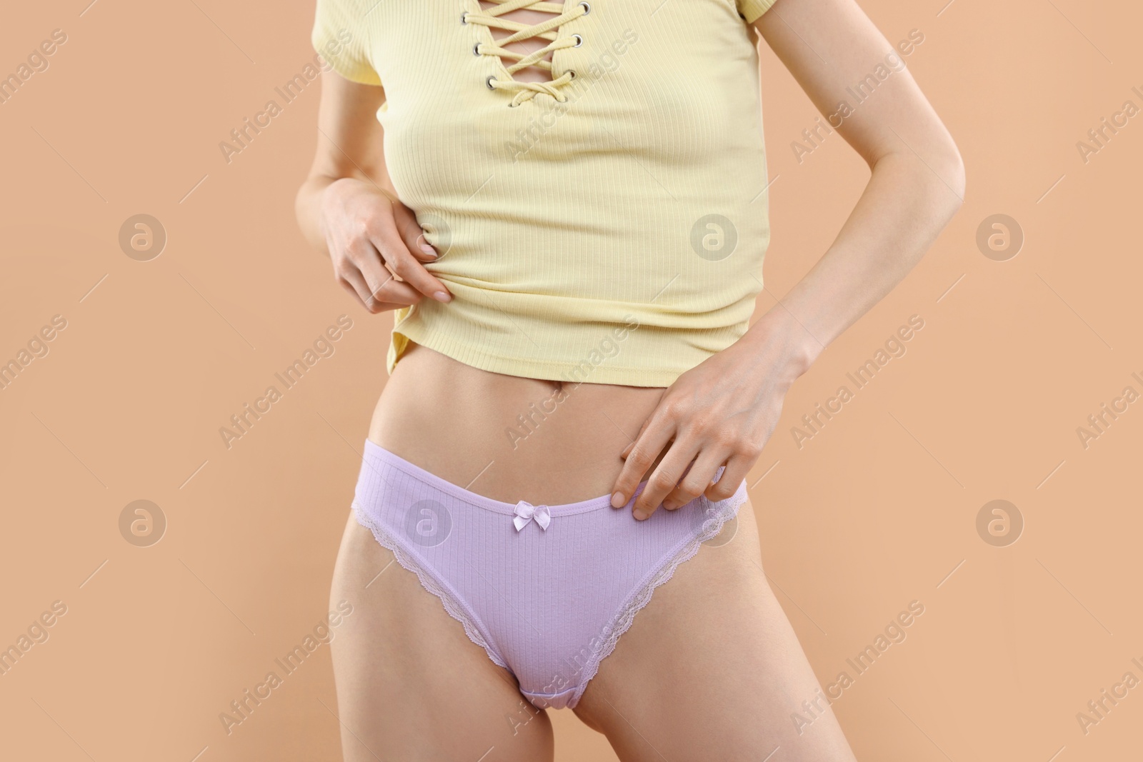Woman wearing beautiful underwear on beige background, closeup Photo of Woman wearing beautiful underwear on beige background, closeup