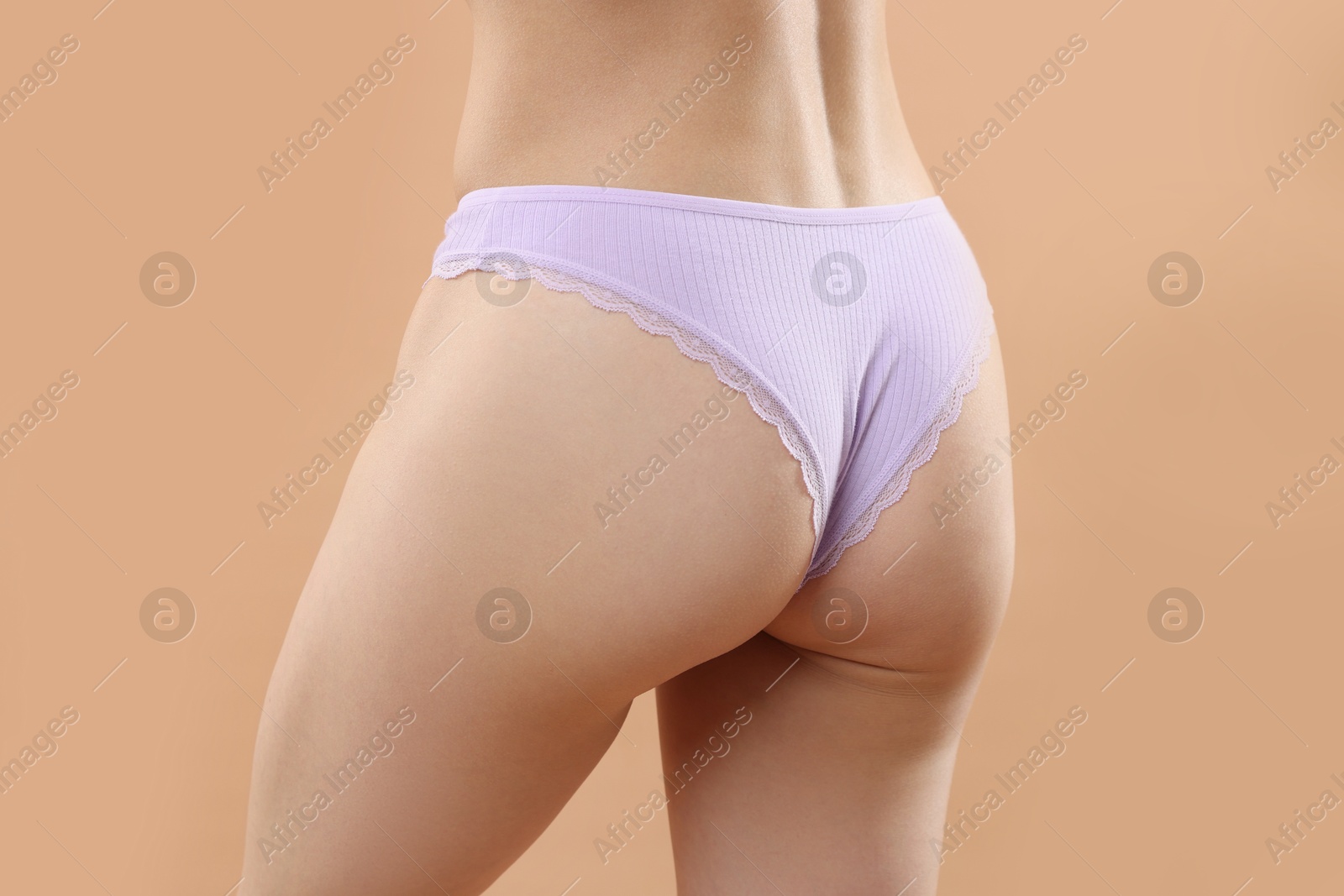 Woman wearing beautiful underwear on beige background, closeup Photo of Woman wearing beautiful underwear on beige background, closeup