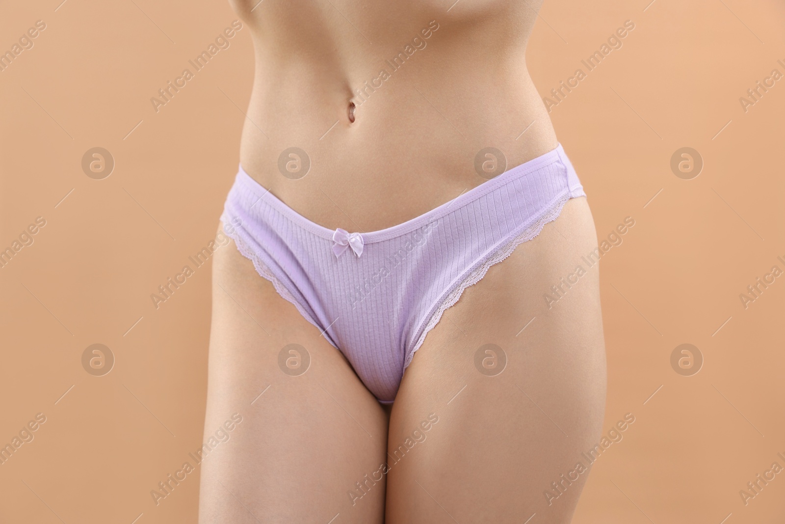 Woman wearing beautiful underwear on beige background, closeup Photo of Woman wearing beautiful underwear on beige background, closeup