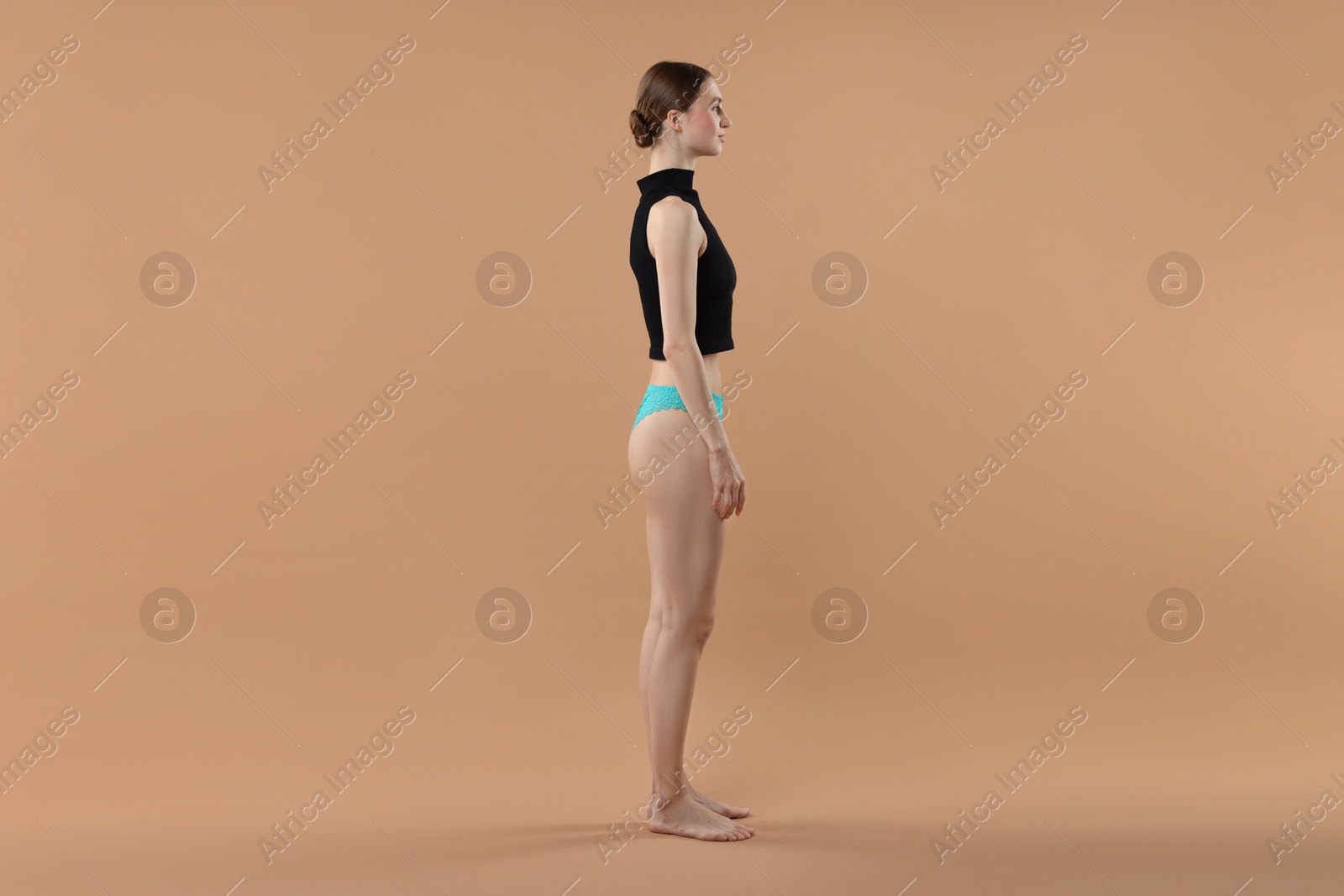 Woman wearing beautiful underwear on beige background Photo of Woman wearing beautiful underwear on beige background