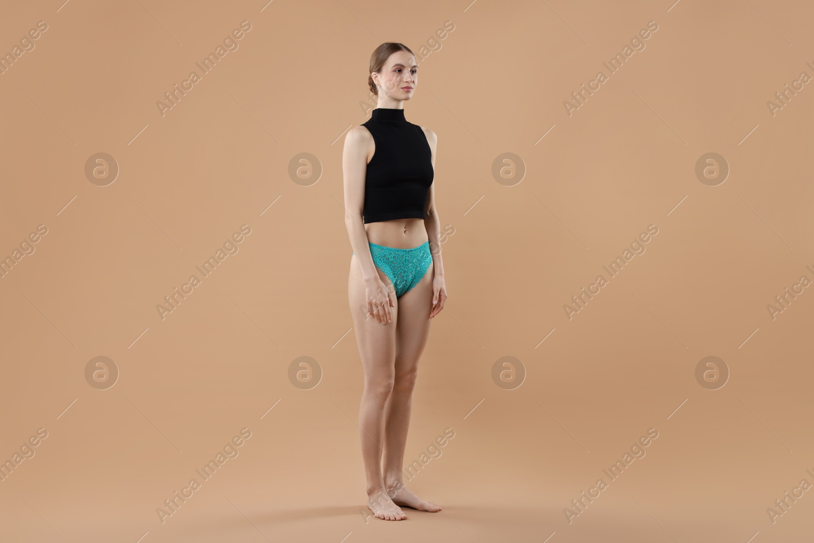 Woman wearing beautiful underwear on beige background Photo of Woman wearing beautiful underwear on beige background