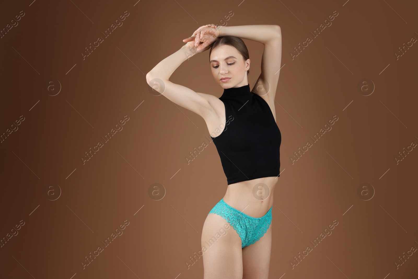 Woman wearing beautiful underwear on brown background Photo of Woman wearing beautiful underwear on brown background