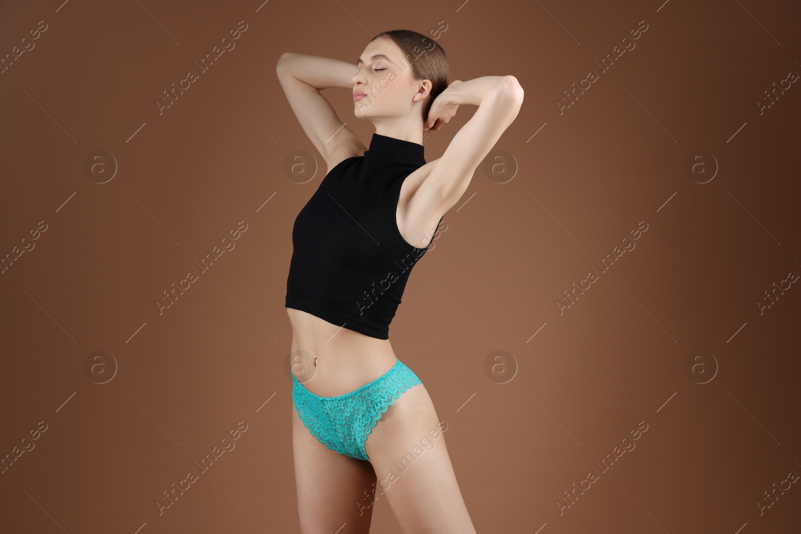 Woman wearing beautiful underwear on brown background Photo of Woman wearing beautiful underwear on brown background