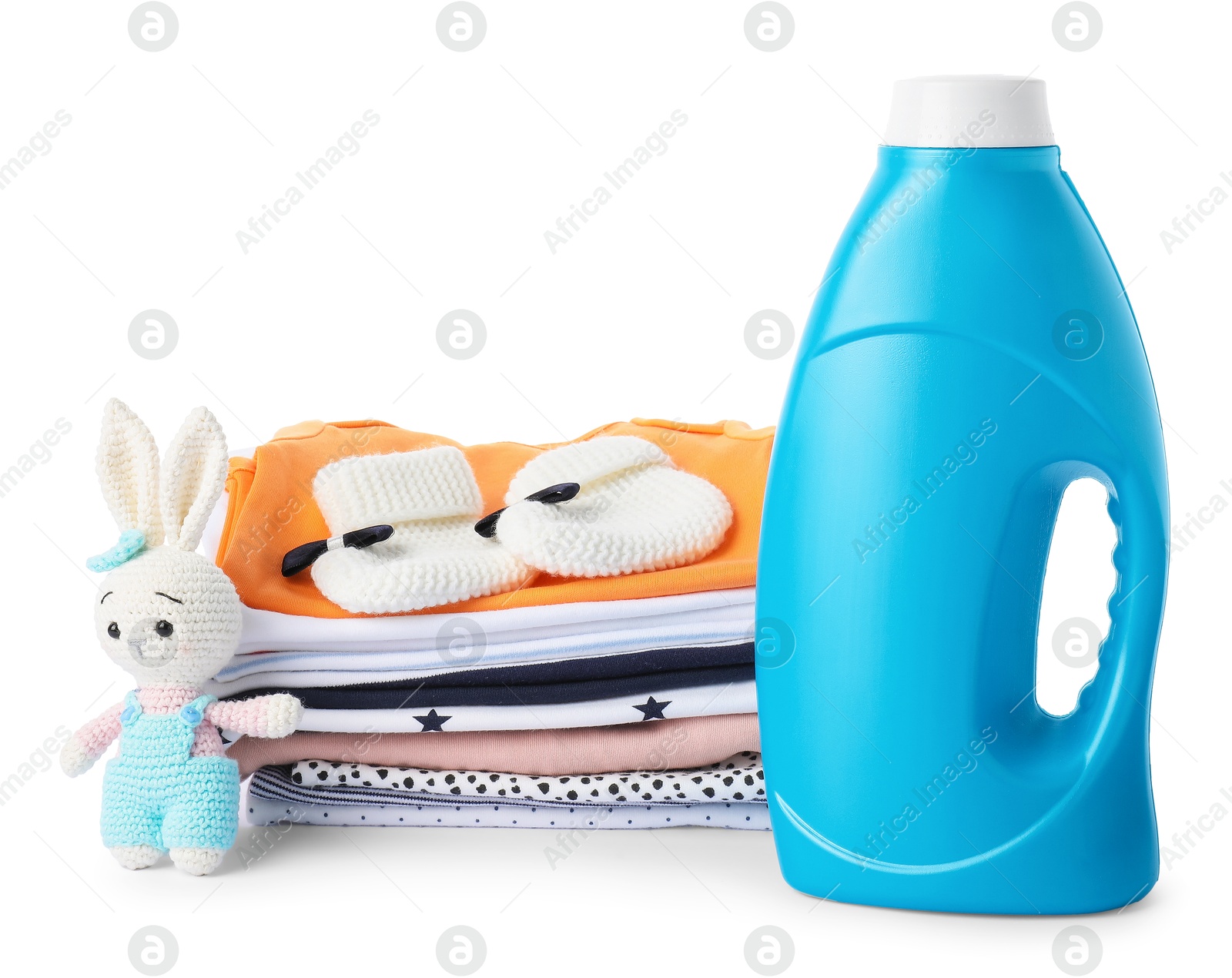 Bottle with fabric softener, shoes, baby clothes and toy isolated on white Photo of Bottle with fabric softener, shoes, baby clothes and toy isolated on white