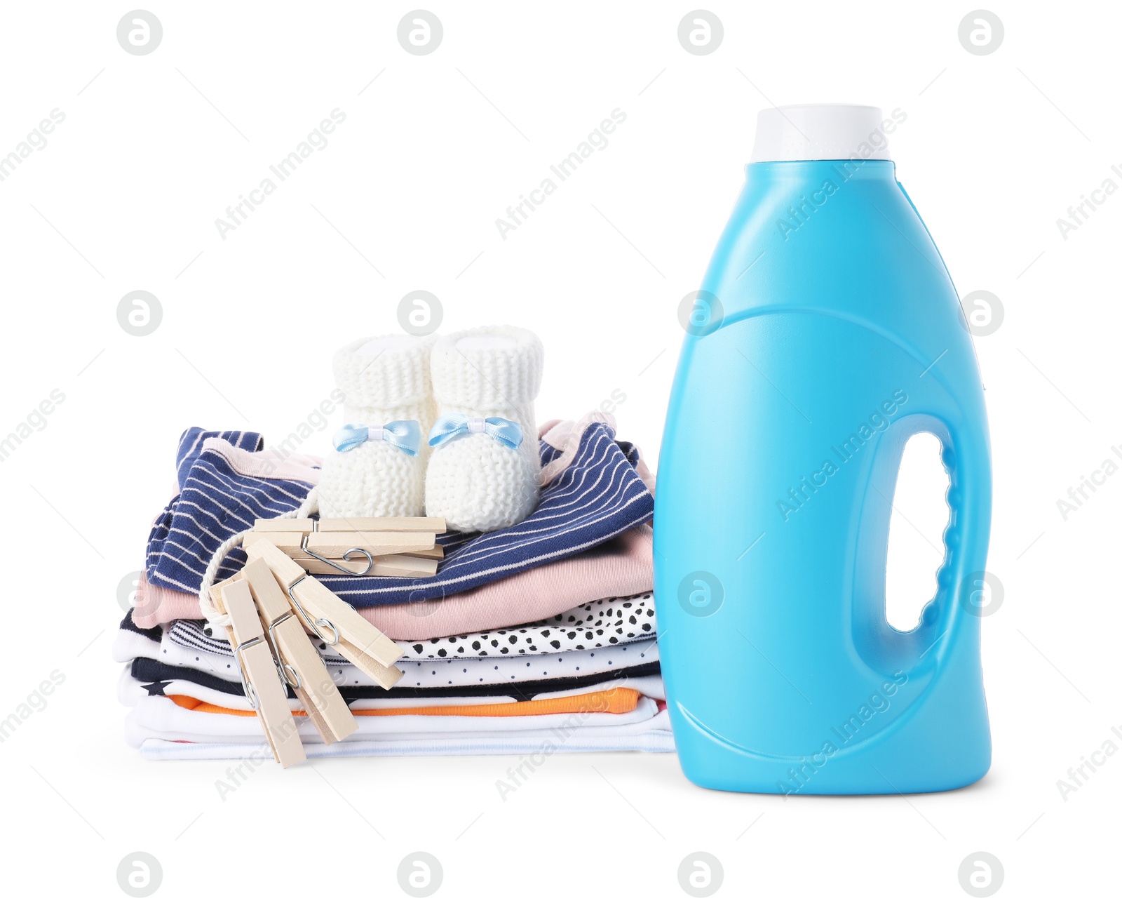 Bottle with fabric softener, shoes, baby clothes and clothespins isolated on white Photo of Bottle with fabric softener, shoes, baby clothes and clothespins isolated on white
