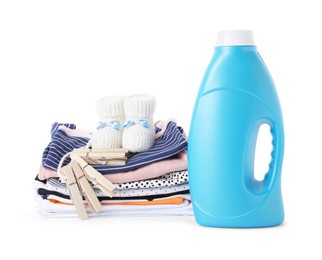 Photo of Bottle with fabric softener, shoes, baby clothes and clothespins isolated on white