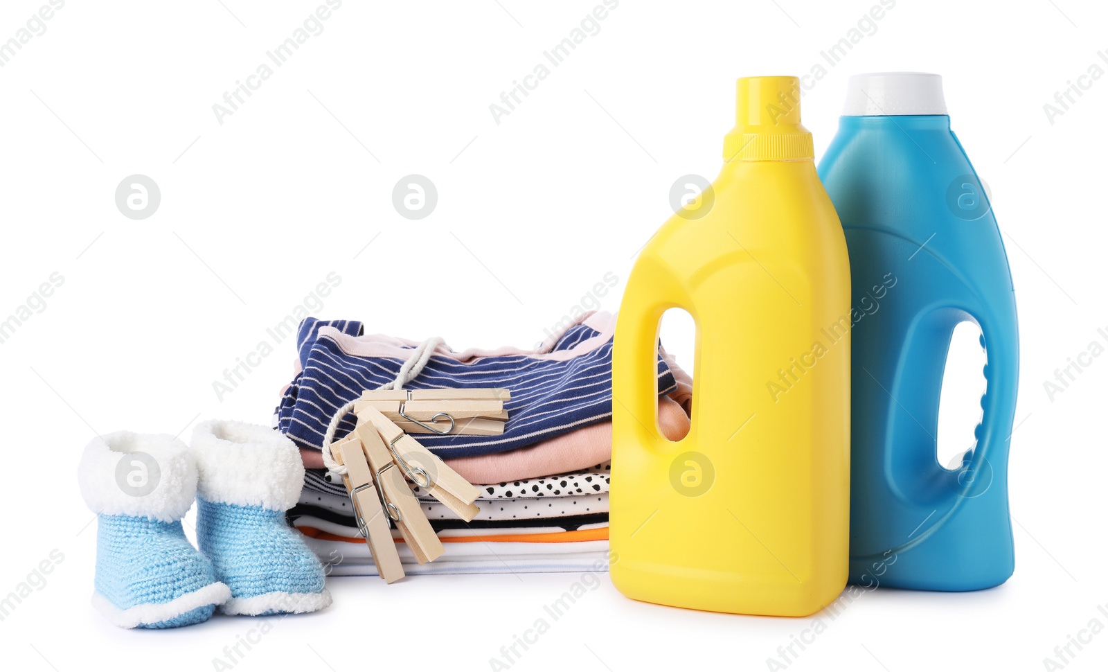 Bottles with fabric softener, shoes, baby clothes and clothespins isolated on white Photo of Bottles with fabric softener, shoes, baby clothes and clothespins isolated on white