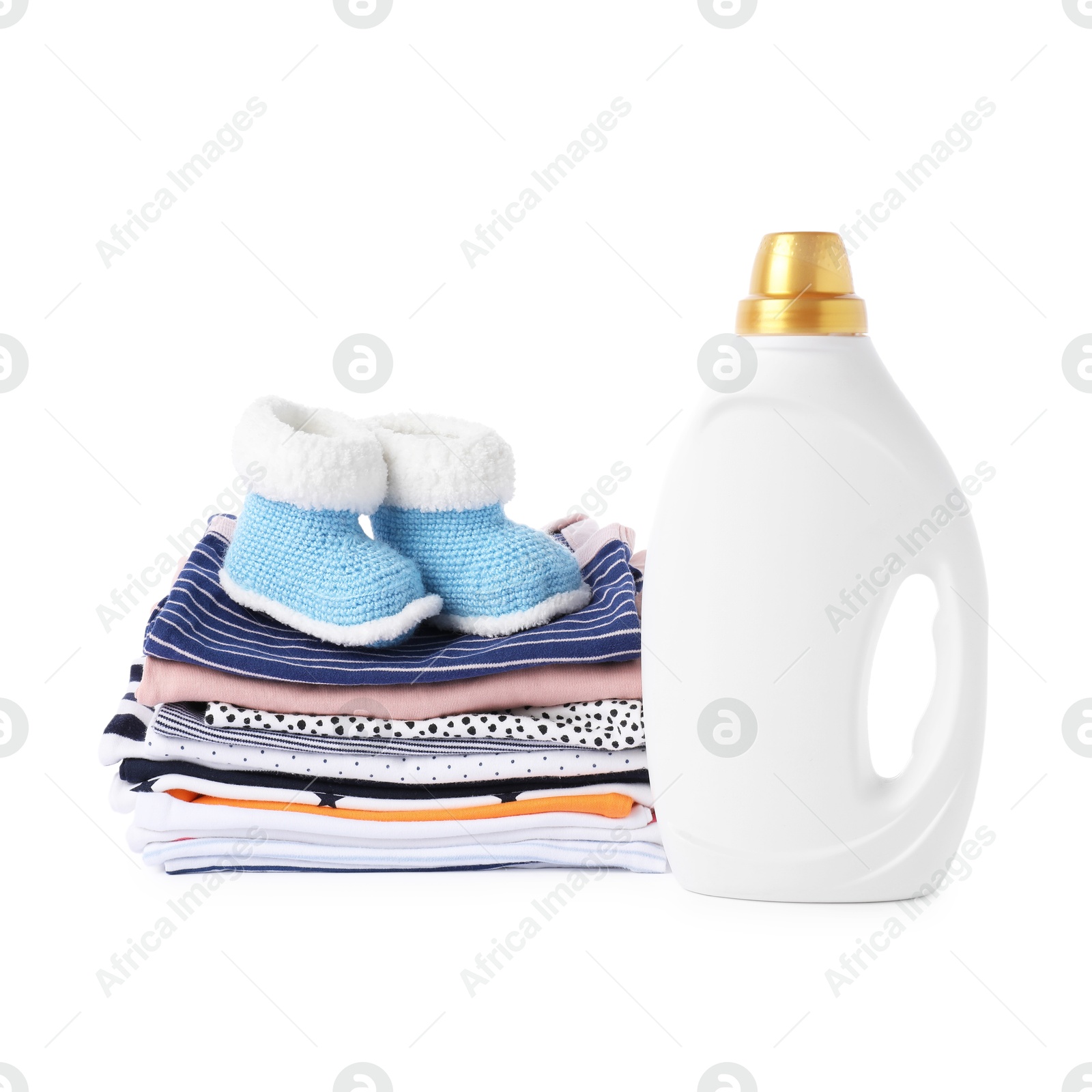 Bottle with fabric softener, shoes and baby clothes isolated on white Photo of Bottle with fabric softener, shoes and baby clothes isolated on white