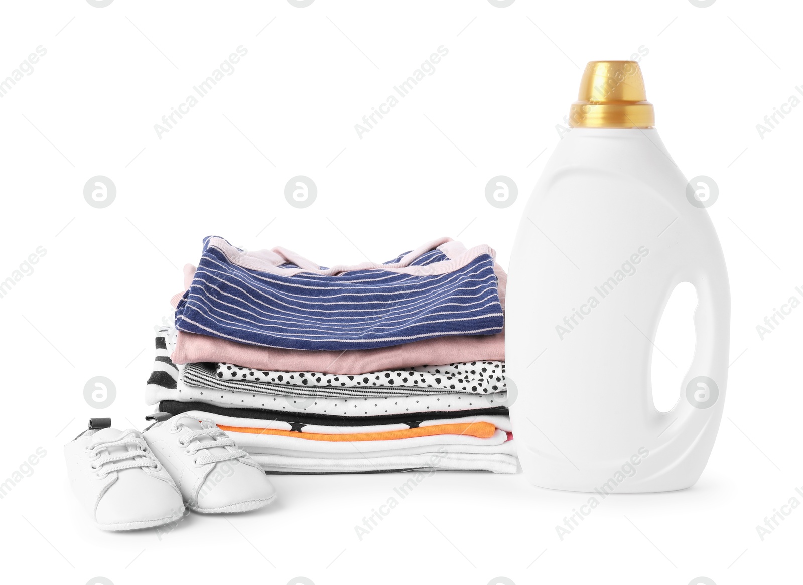 Bottle with fabric softener, shoes and baby clothes isolated on white Photo of Bottle with fabric softener, shoes and baby clothes isolated on white