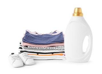 Photo of Bottle with fabric softener, shoes and baby clothes isolated on white