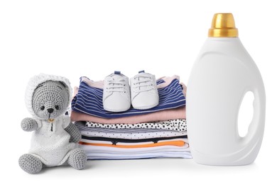 Photo of Bottle with fabric softener, shoes, baby clothes and toy isolated on white